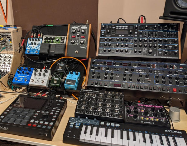 Two Adapt L2 stands holding Peak, OB-6 desktop, plus lots of effects pedals.