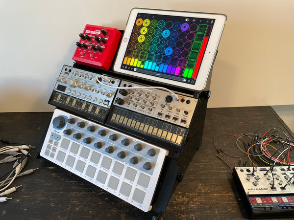 Desktop synth stand holding Volcas, Beatstep and iPad.
